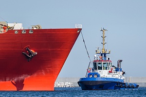 Tug boat being pulled by ship