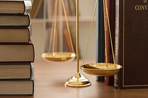 Law books and scale on desk