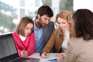Family of three consisting girl man and woman finalizing youth sports insurance plan in front of consultant