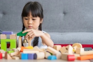 girl playing with toys on sofa