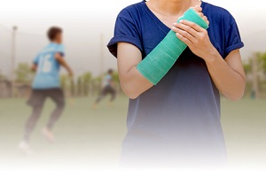 broken arm with green cast on blurred background kid soccer player in academy