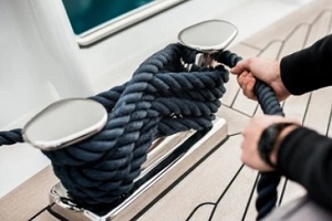 man tightening boat rope