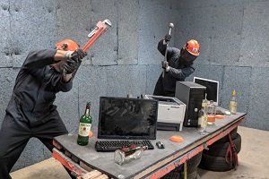 people destroying computers in an anger room