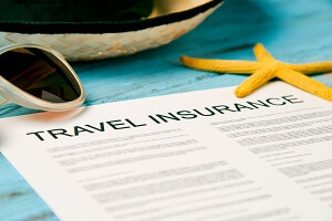sunglasses straw hat and travel insurance policy