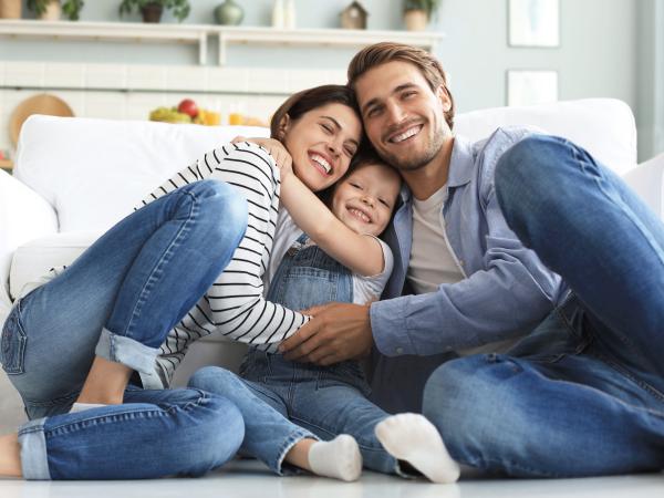 young family embracing after securing personal insurance