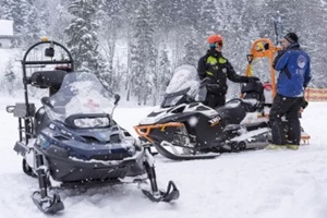 mountain assistance rescue patrol with snowmobiles in ski winter season