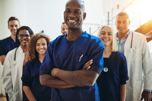 Smiling doctor standing in a hospital with his staff