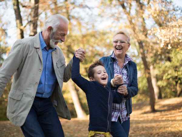 A grandfather, a grandmother and their grandson strolling through an outdoors in new jersey